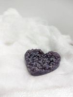 Photo shows the heart-shaped agate with distinct botryoidal formations on a white soft surface highlighting color and texture.