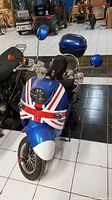 Front-left angle view showing blue Union Jack front fairing, headlight, indicators and wheel condition