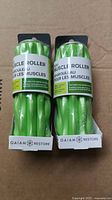 Front view of two sealed green Gaiam Restore Mini Muscle Rollers in original packaging lined side by side