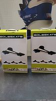 Two SoleSkate three-wheeled skateboards in their original boxes, front view showing product images and brand.