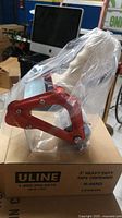New ULINE 3 inch heavy duty tape dispenser in red, sealed in plastic on top of brown ULINE box.