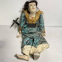 Full view of the Asian marionette showing detailed silk clothing, glass bead decorations, real hair, and porcelain eyes.