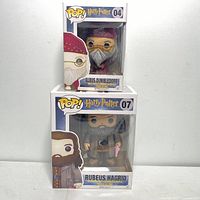 Front view of stacked Albus Dumbledore and Rubeus Hagrid Pop! boxes showing figures inside.