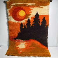 Hand hooked wall rug showing the full sunset landscape design with silhouette trees and reflection.