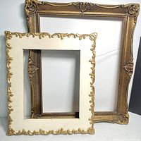 Photo of two vintage ornate frames, one gold-toned larger behind a smaller cream-colored frame with gold detailing
