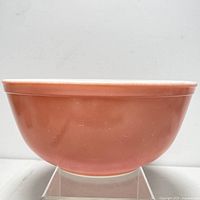 Side view showing the solid pink exterior with a rounded lip and flat bottom.