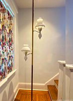 Full view of vintage pole lamp standing next to wall and window showing overall height and lamp design.