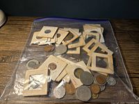 Photo showing large ziploc bag filled with mixed international coins, some loose and some in paper holders