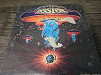 Front cover of Boston vinyl album showing spaceship graphic and Earth with cosmic background.