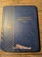 Front cover of a blue Canadian Small Cents fold with gold decorative elements and text.