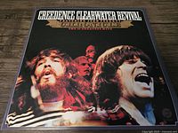 Front cover of Creedence Clearwater Revival's album 'The 20 Greatest Hits' featuring band members shown singing and playing music.