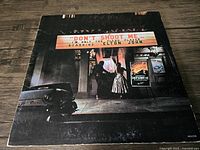 Front cover of Elton John vinyl album featuring a vintage theater scene and marquee with album title.