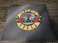 Front cover of Guns N' Roses Greatest Hits vinyl showing iconic band logo with pistols and roses.