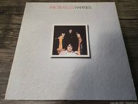 Front cover of The Beatles Rarities vinyl album featuring a white textured background with a centered color photo of the band members.