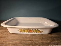 Side view of white rectangular Corningware lasagna dish showing the colorful "Spice of Life" vegetable pattern.
