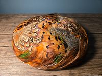 Top view photo showing the round feather arrangement and color patterns of the vintage feather hat