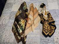 Photo showing three scarves laid out side by side on fabric background, displaying different colors and patterns.