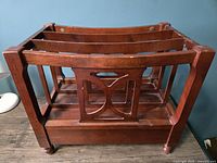 Front and side view of vintage wooden magazine or vinyl record rack showing three vertical compartments and decorative side cutouts.