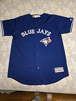 Front view of the blue Toronto Blue Jays youth XL jersey showing buttons, team name, and logo.