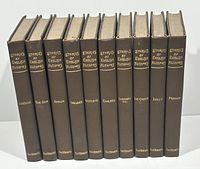 Front view of all ten volumes upright showing chocolate brown cloth bindings and gilt spine lettering.