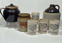 Overview of entire lot: four marmalade jars, Pfalzgraff bean pot with lid, Robertson’s mincemeat jar, and stoneware crock jug.