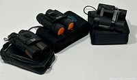Three binoculars with cases arranged showing each model distinctly to identify brand, model, and included cases.