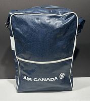 Front view of vintage Air Canada blue vinyl travel bag with white trim and Air Canada logo in white.
