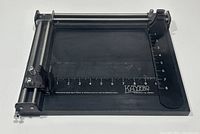 Top angle view showing the entire mat cutter with measuring scale and rollers.