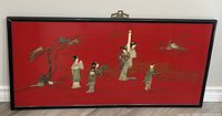 Full view of the red Chinoiserie panel with black frame showing figures and nature scene with mother of pearl relief.