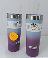 Photo of two 32oz insulated tumblers side by side, showing gradient blue to purple design, clear lids with reusable straws, silicone bumpers, and Ello branding.