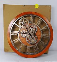 Full front view of large gear-style wall clock with warm wood frame and Roman numerals
