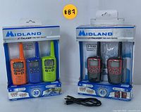 Two boxed sets of Midland X-Talker two-way radios: one set of three colorful radios and one set of two black and red rechargeable radios with USB cables outside the packages.