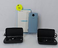 Front shot of Veger power bank with packaging and two black wireless microphone headsets in travel cases.