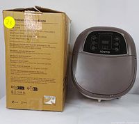 Foot spa massager unit with its original box showing product specifications and branding.