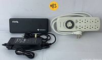 Full view of the Plugable Thunderbolt docking station, power adapter, and programmable power strip arranged together showing the lot contents
