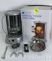Flexzion vertical tower oven grill rotisserie complete with original box, metal drip tray, skewers, rotisserie forks, and handle.