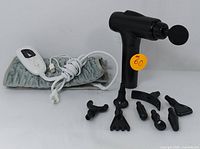 Percussion massager with 8 massage heads and gray heating pad with controller on white background