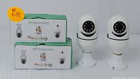 Two boxed WiFi Panorama Cameras with two unboxed white cameras on bases displayed in front.