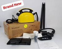 Complete steam cleaning set shown with main yellow unit atop original product box, plus multiple accessories and instruction manual arranged for clarity.