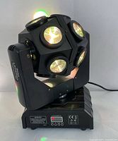 Front angle showing white LED lights on the moving head unit and the LCD control panel on the base