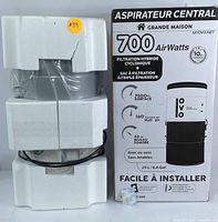 OVO central vacuum system main unit housed in styrofoam packaging next to original retail box labeled with product features including 700 AirWatts suction and 25L capacity.