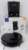 Overview showing robot vacuum, base station, original box and instruction manual