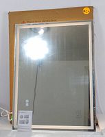 Front view of the LED mirror showing reflective surface and touch control icons on the glass.