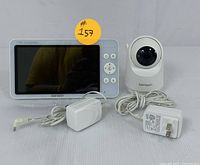 Photo showing the Bonoch 7-inch HD baby monitor, the camera, and both their power adapters with cords.