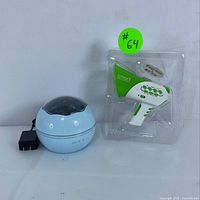 Both items shown together: blue galaxy projector night light with power adapter and green and white smart voice changer toy inside plastic packaging.