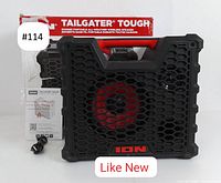 Front view of ION Tailgater Tough speaker with original packaging and charging cable. The speaker is black with a red handle and red speaker cone visible through the grille.