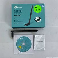 Front of box showing model and key features, with adapter, setup disc and manual laid out below.