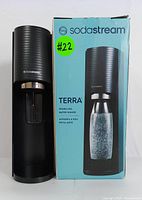Front view of SodaStream Terra sparkling water maker alongside original retail box, showing model number TER-001 and branding