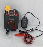 Avid Power digital tire inflator with LCD screen, control buttons, and black/red design alongside a compact 3 AMP 6V/12V battery charger with attached cables and clamps.