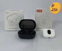 Two pairs of true wireless earbuds (G18 in white and S75 in black) with their original boxes and charging cases.